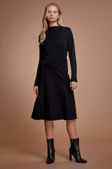 דוגמנית מציגה חצאית צנועה בגזרה מתרחבת בצבע שחור