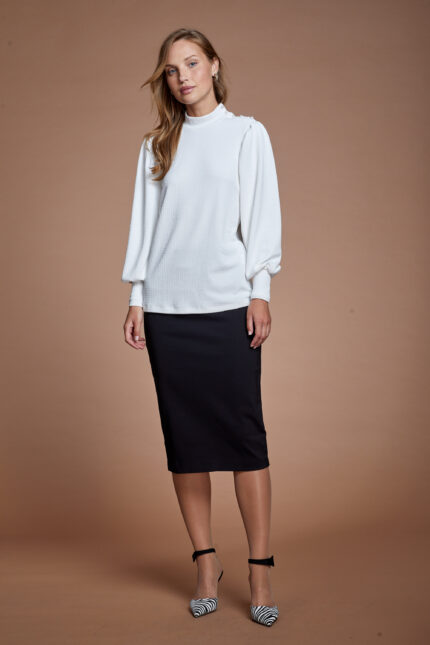 דוגמנית מציגה לוק צנוע של חולצה חגיגית במידות גדולות בצבע לבן