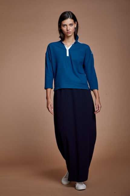 דוגמנית מציגה חולצת כותנה צנועה בסגנון פולו בצבע כחול