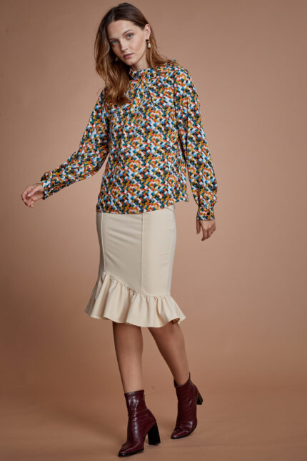 דוגמנית מציגה חולצה צנועה מודפסת רטרו וחצאית בצבע שמנת