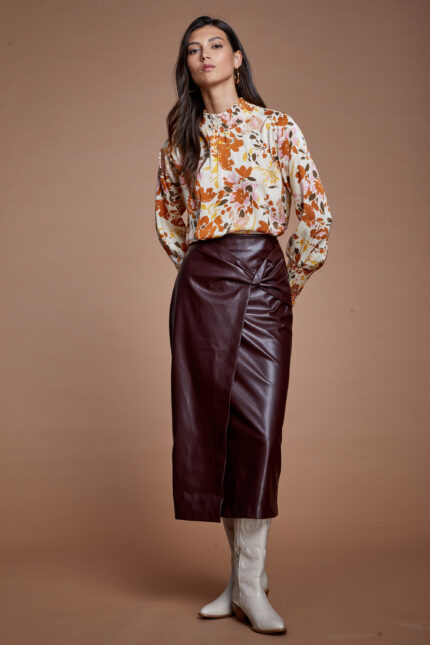 דוגמנית מציגה לוק צנוע של חצאית דמוי עור צנועה באורך מידי בצבע בורדו
