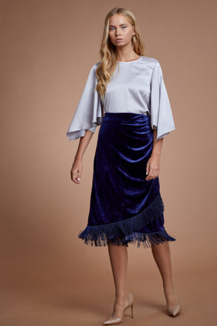 דוגמנית מציגה לוק צנוע של חולצה מכופתרת צנועה וחצאית קטיפה צנועה בצבע כחול
