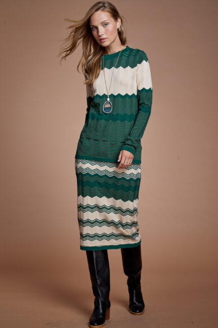 דוגמנית מציגה סט סריג צנוע של חצאית וסריג פסים בצבע ירוק