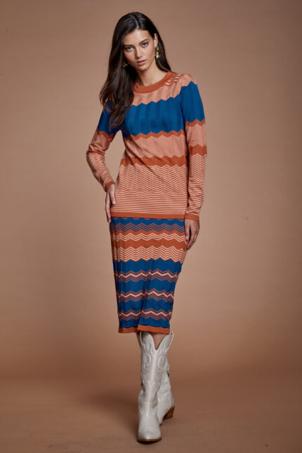 דוגמנית מציגה סט צנוע של סריג וחצאית עשוי סריג בגוונים כחול וחום