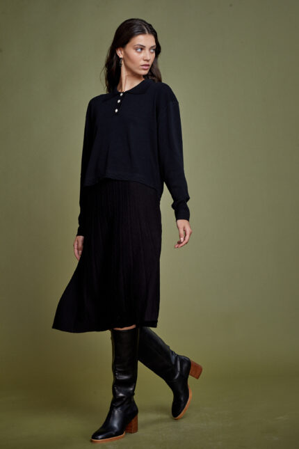 דוגמנית מציגה לוק צנוע וחורפי של חצאית סריג צנועה וסריג צנוע עשוי וסקוזה בצבע שחור