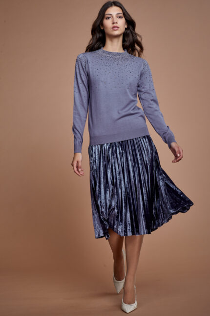 דוגמנית מציגה לוק צנוע של חצאית פליסה צנועה עשויה פליסה קטיפה גוון אפור