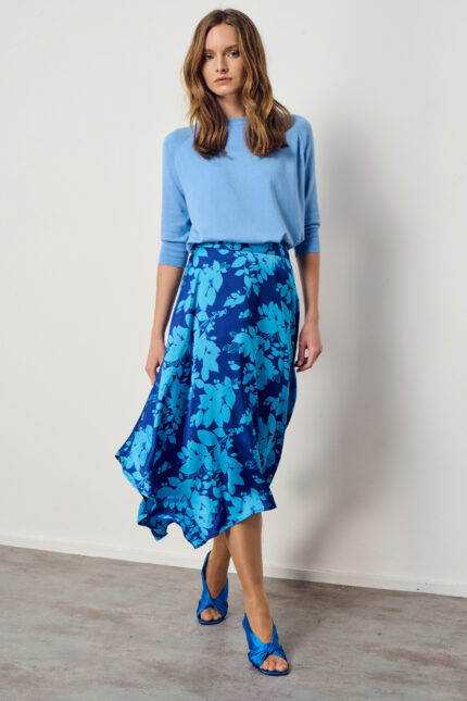 דוגמנית מציגה לוק צנוע של חצאית אסימטרית בגוונים כחולים