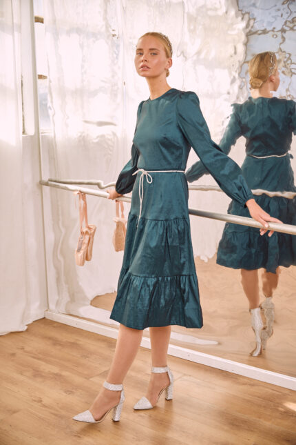שמלת ערב צנועה בדוגמת קומות מתרחבת עשויה בד מבריק בצבע פטרול עם חגורת יהלומים במותן
