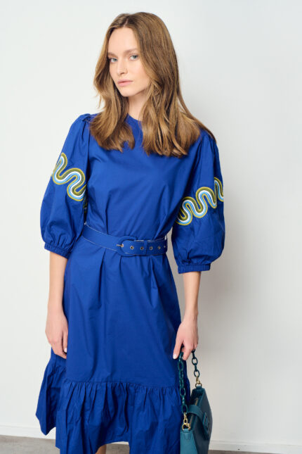 תמונת תקריב של שמלת כותנה בצבע כחול בגזרה מתרחבת עם דוגמת צבע בשרוול