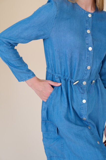 תמונת תקריב של שמלה דמוי ג'ינס עם כפתורים קדמיים וחגורת מסילה במותן
